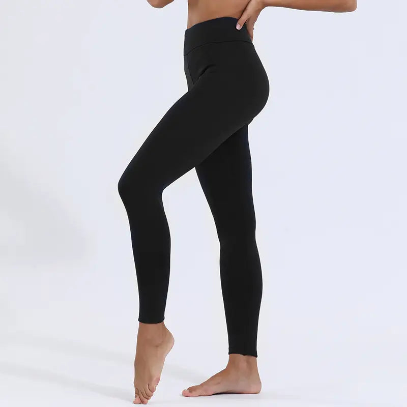 Black high-waisted royale essence lux winter leggings made of smooth high stretch fabric with fleece lining for warmth.