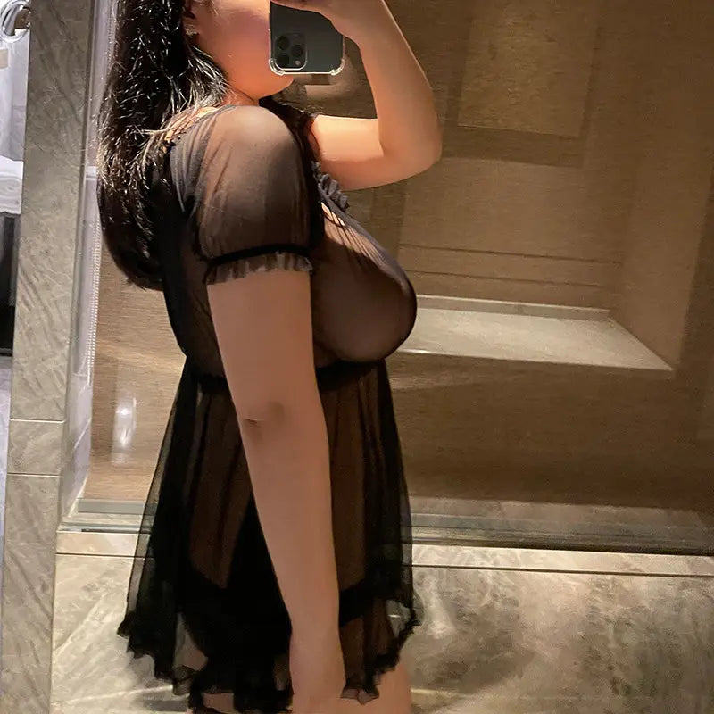 Plus size black sheer mesh dress with short sleeves and ruffled hemline.
