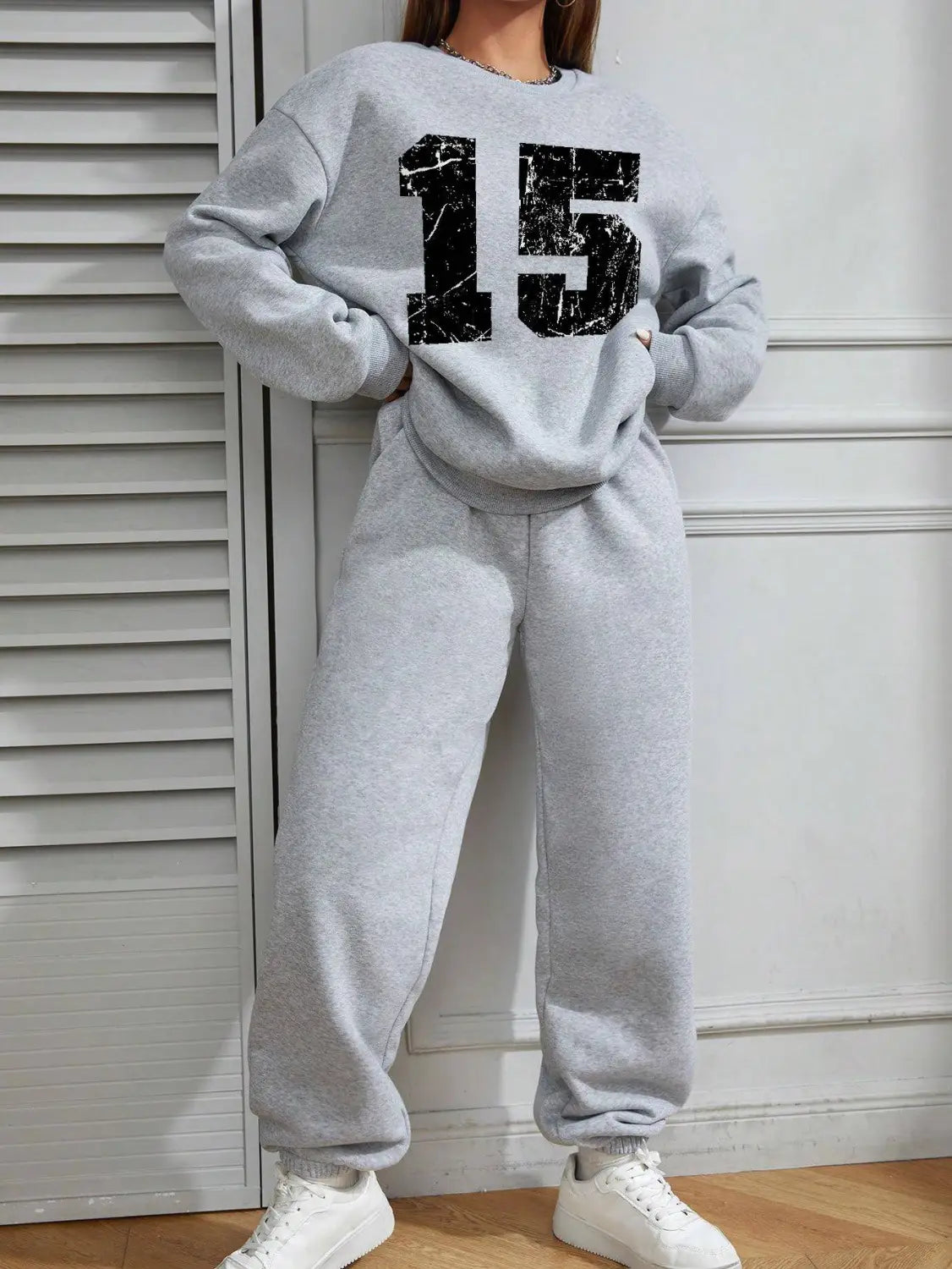 Gray crew neck sweatshirt featuring a black distressed white number 15 graphic on the front.