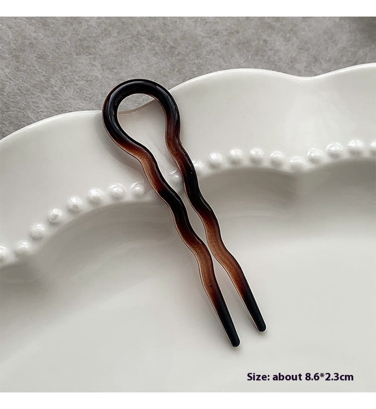a sleek wavy two-pronged hairpin with a glossy gradient finish from deep black to rich brown designed as a tortoiseshell bun lazy updo gadget for secure head bun lazy styling