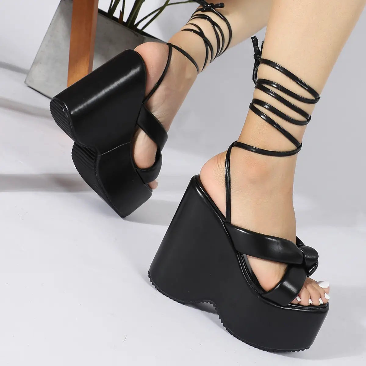 black platform wedge high sandals with thick glossy straps and lace-up ankle ties in a high heel platform design