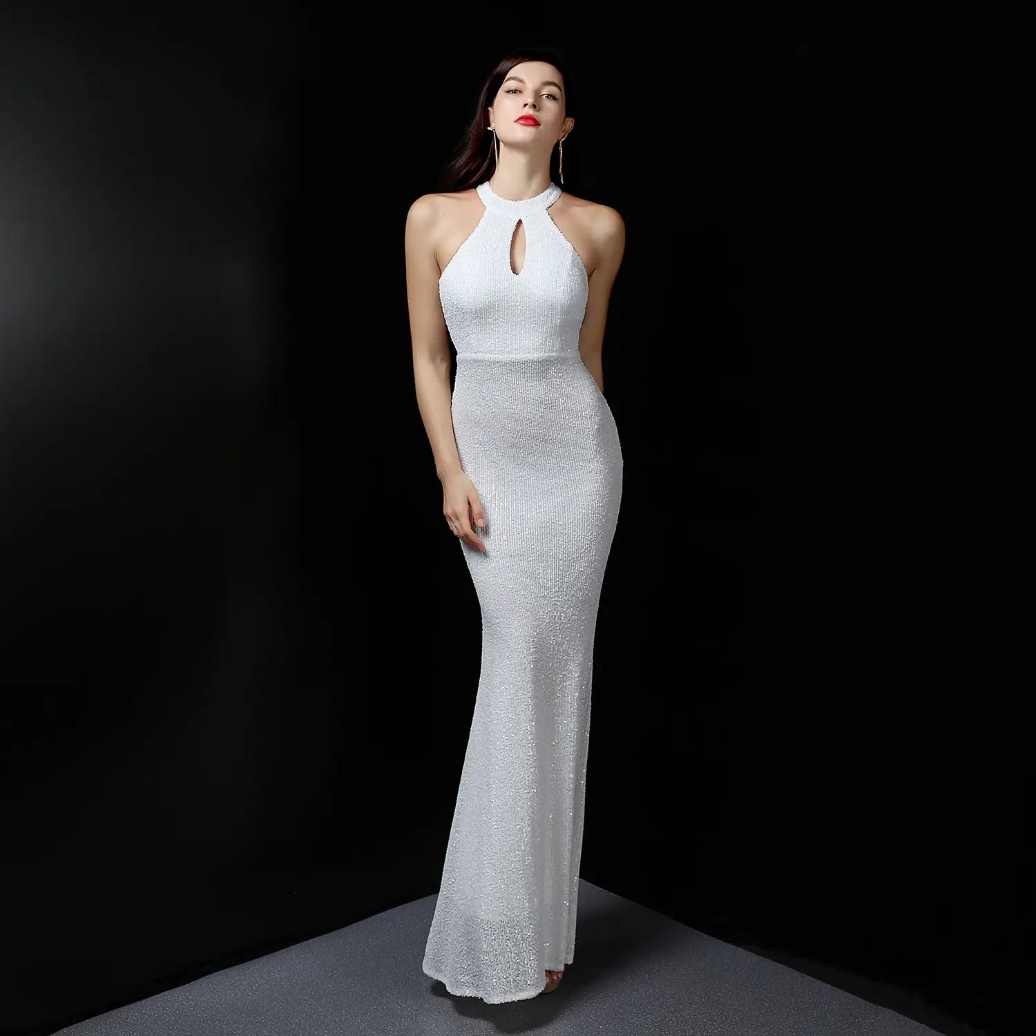 A shimmering white sequin mermaid evening dress made of polyester fiber featuring a halter neckline and keyhole detail.