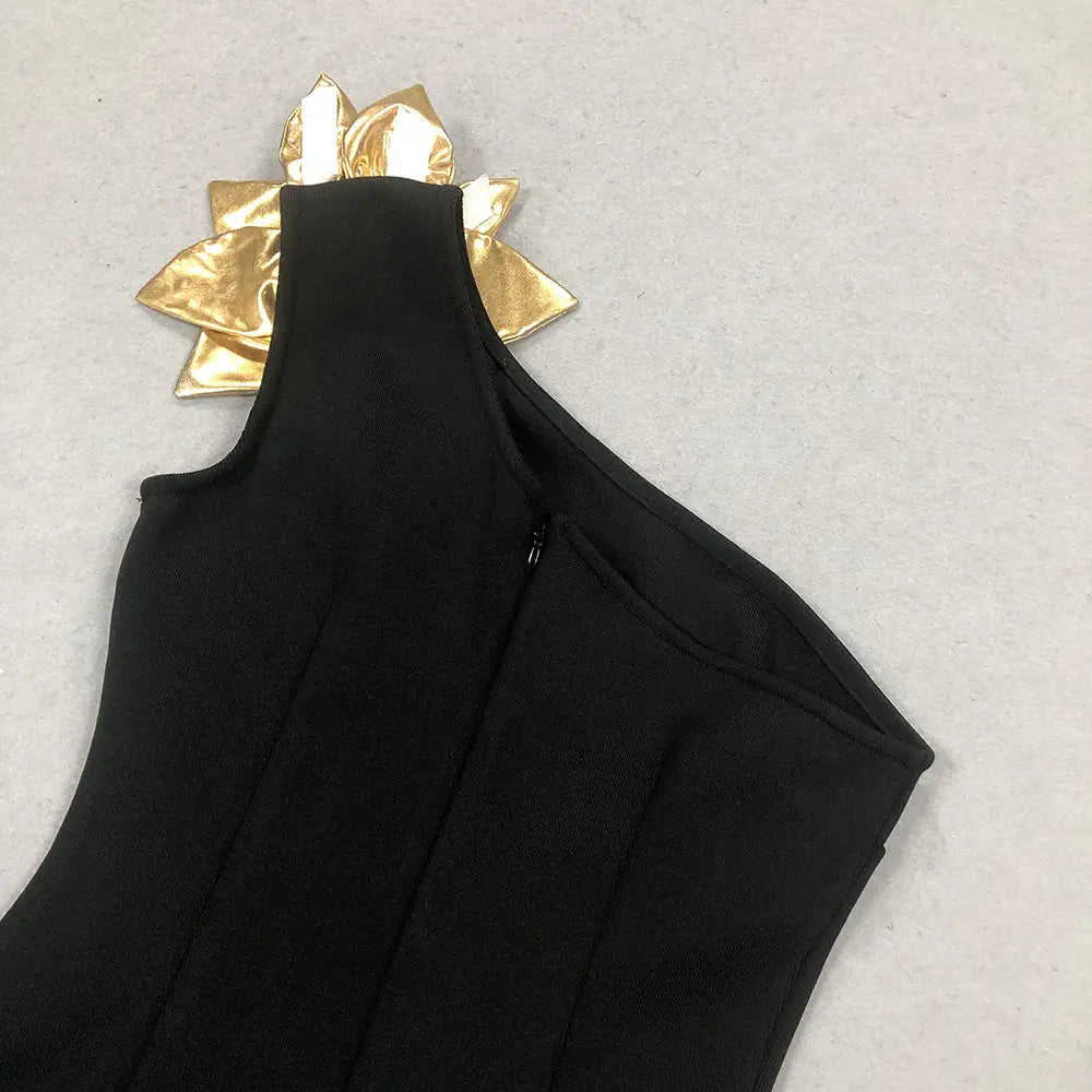 black satin bandage golden flower maxi dress featuring a one-shoulder design with a gold metallic flower accent at the neckline