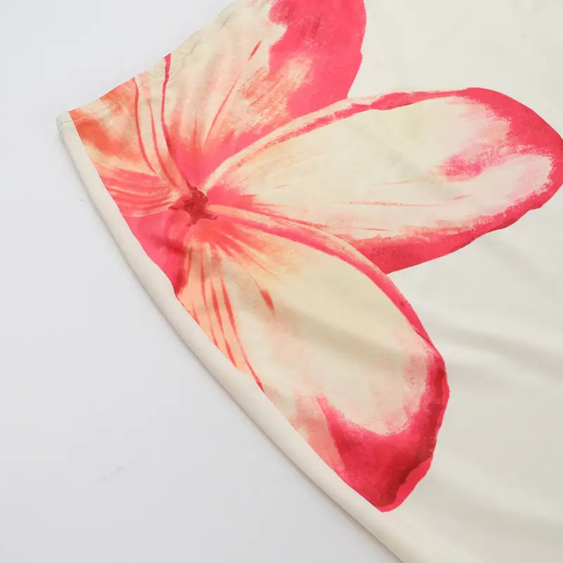 a soft cream-colored fabric scarf with a large vibrant pink and white tropical flower print featuring delicate watercolor-style edges for an elegant slim print floral top and skirt set