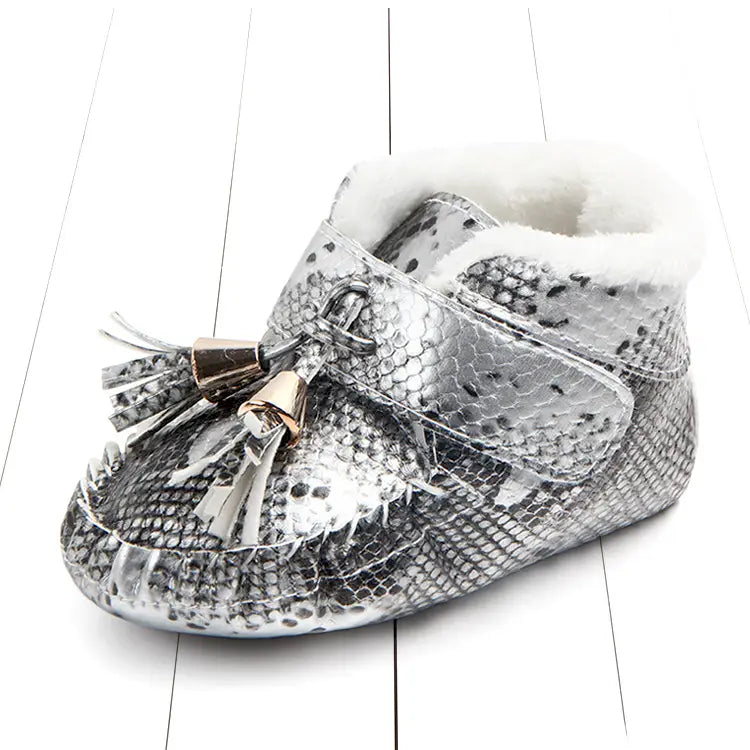 silver snake-print baby shoes with white faux fur lining and gold-toned tassel accents designed as non-slip toddler shoes