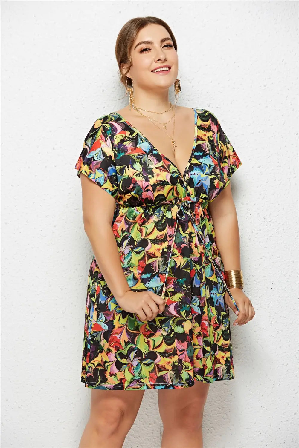 A vibrant short-sleeved printed deep v-neck dress with an elastic waist featuring a bold multicolored butterfly design on black fabric.