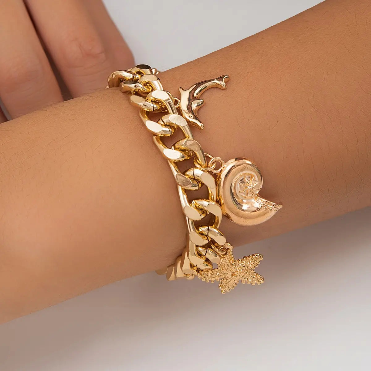 Gold-toned chunky chain bracelet featuring conch dolphin seashell and starfish charms from the boho conch dolphin choker necklace bracelet set.