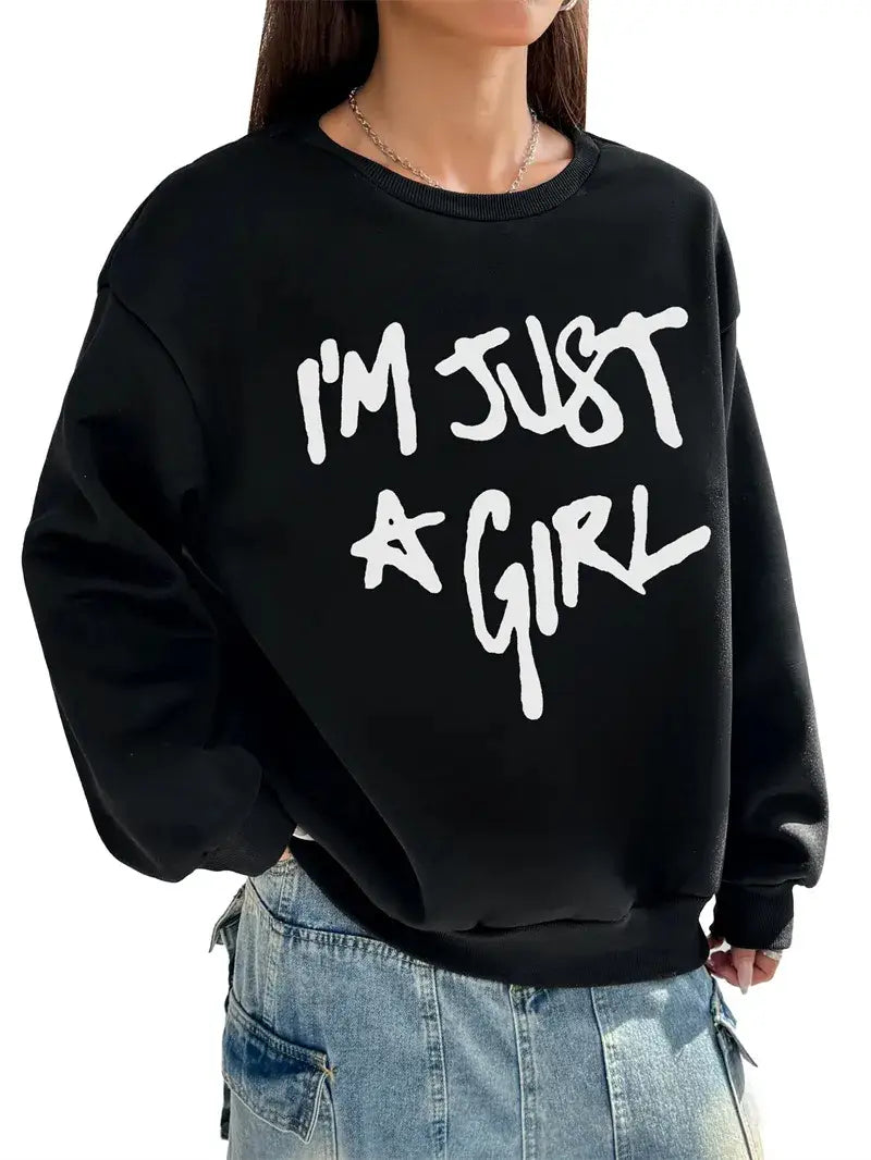 Black oversized sweatshirt featuring bold white imprinted text im just a girl in a round neck design, ideal for casual wear in the girl print round neck sweatshirt collection.