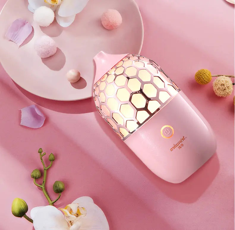 a pink asakusa pink aroma diffuser with a smooth plastic body and a honeycomb-patterned metallic mesh top designed for humidifying and aromatherapy purposes