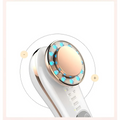 White and rose gold 7 in 1 led facial machine skin care massager with circular head featuring blue led lights and peach pad