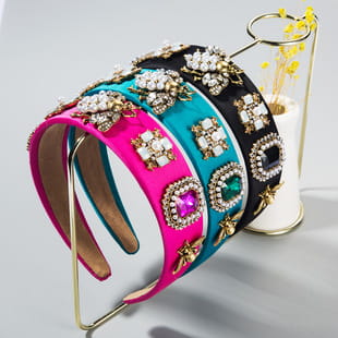 A vibrant baroque colorful headband in hot pink satin featuring a central square rhinestone accent and gold-tone decorative elements.
