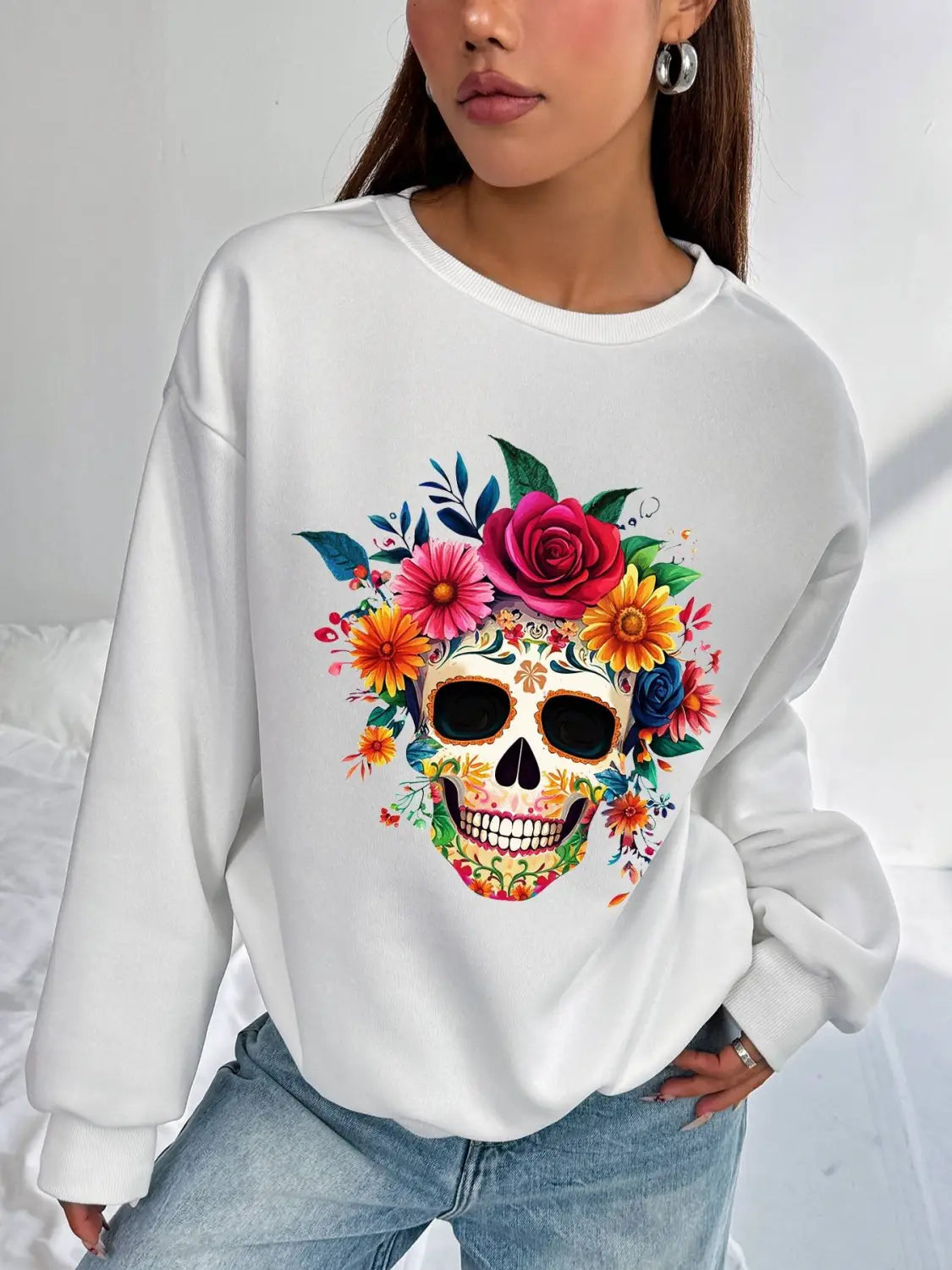 white basic long sleeve crew neck sweatshirt for daily wear featuring a vibrant colorful floral skull design with roses and blossoms in pink yellow orange blue and green