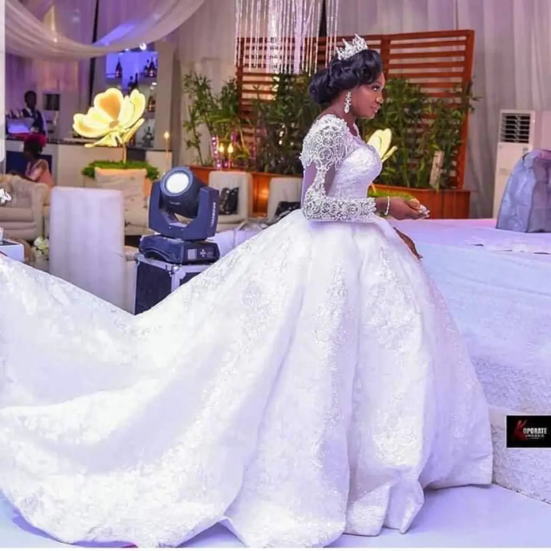 a white lace african wedding dress with long sleeves and an elaborate train designed for wedding dress long wear