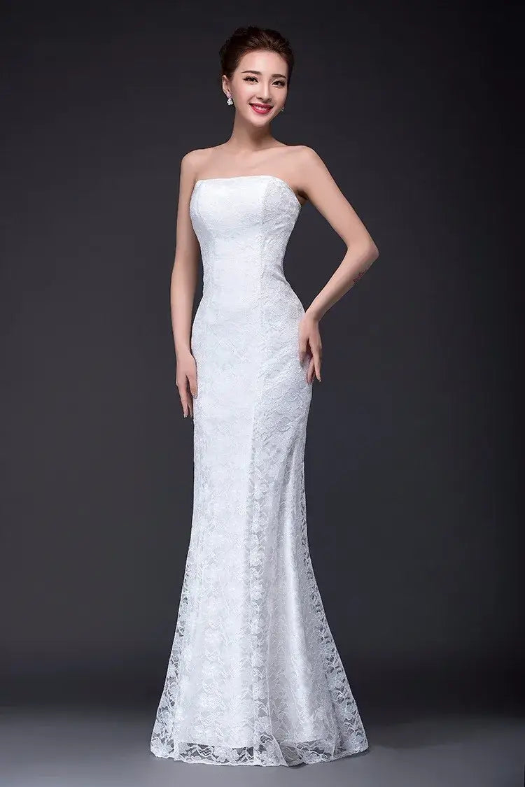 A white strapless mermaid-style wedding dress with intricate lace detailing and a fitted bodice featured in a lace mermaid wedding dress long dress fuchsia collection.