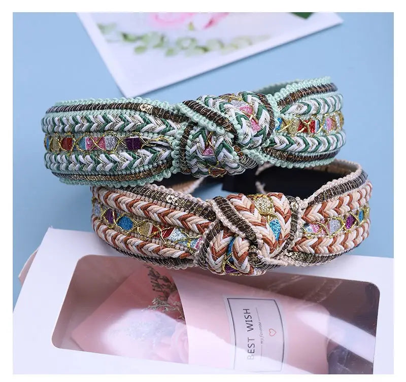 two mint green fabric knotted hair accessories featuring intricate bohemian woven designs with colorful embroidered details and metallic accents