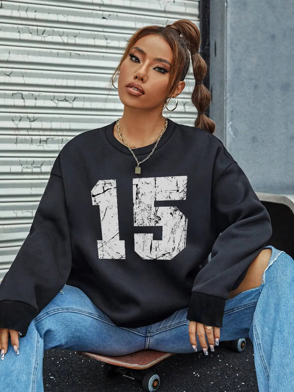 Black oversized crew neck sweatshirt featuring a distressed white number 15 graphic on the front.
