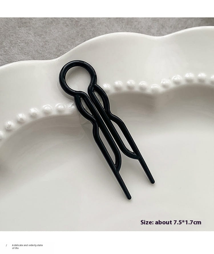 Black metal hair clip with a sleek twisted design and looped top for bun lazy updo and lazy updo gadget styling.