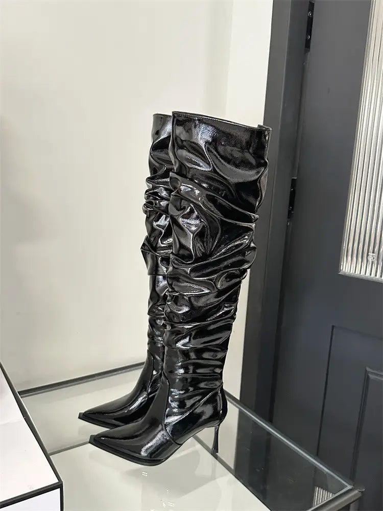 black patent leather knee-high boots with ruched glossy texture and pointed toe design featuring stiletto heel pile style perfect for autumn stiletto heel fashion