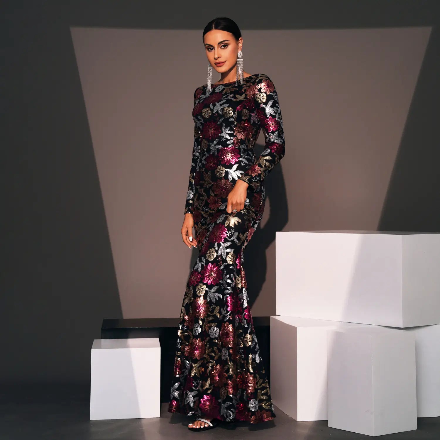 A black mermaid-style evening gown long sleeve featuring intricate burgundy and metallic gold floral embroidery.