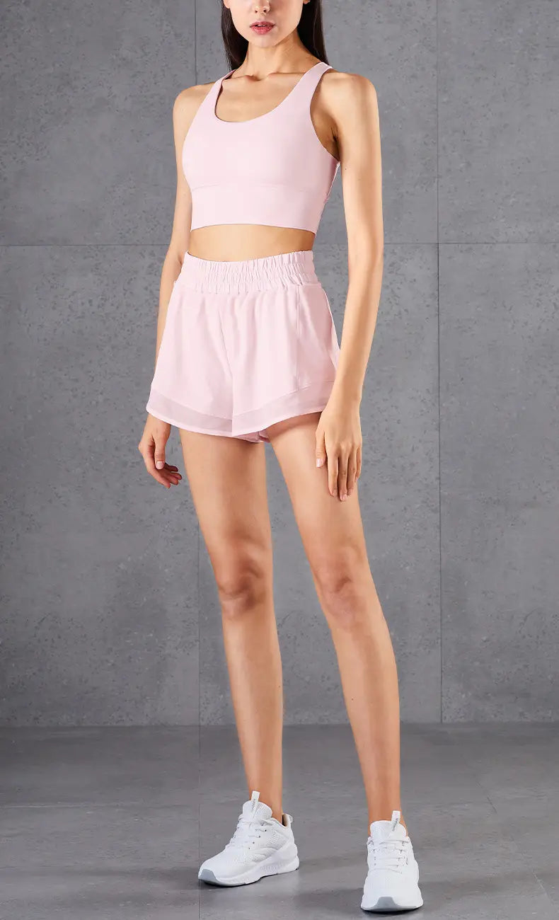 pink mesh pockets fitness two-piece athletic set featuring a cropped top and high-waisted shorts made from lightweight breathable fabric for activewear use