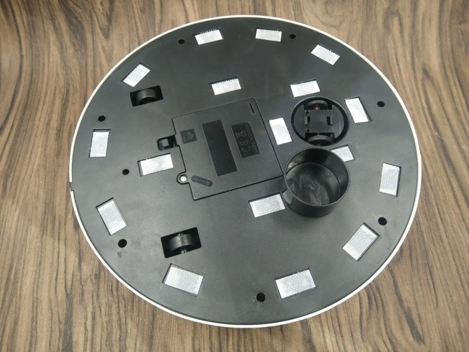 black circular robot household automatic sweeping machine base with white trim and rectangular reflective stickers for efficient sweeping robot household use