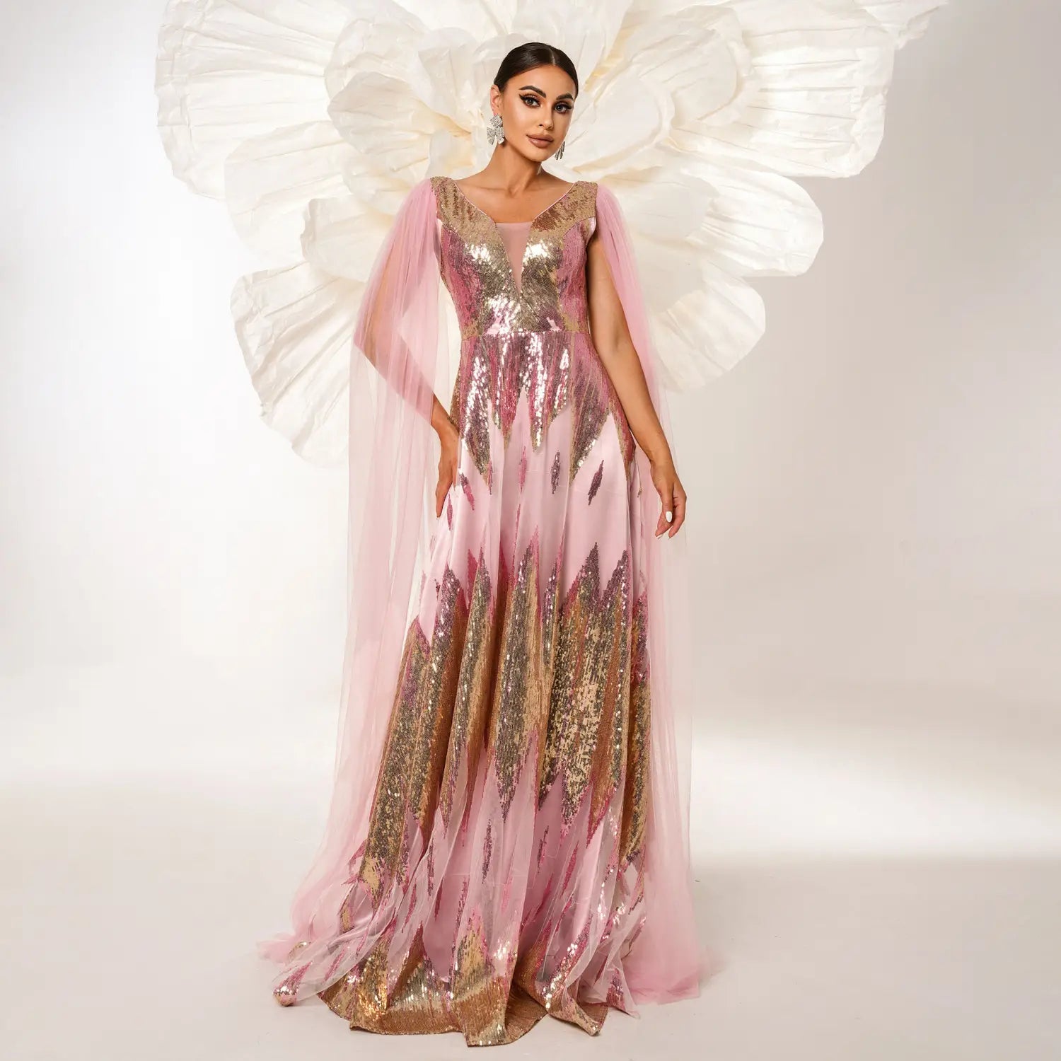 a flowing pink and gold mesh long sleeve sequins large swing dress featuring a sheer capelet with intricate detailing.