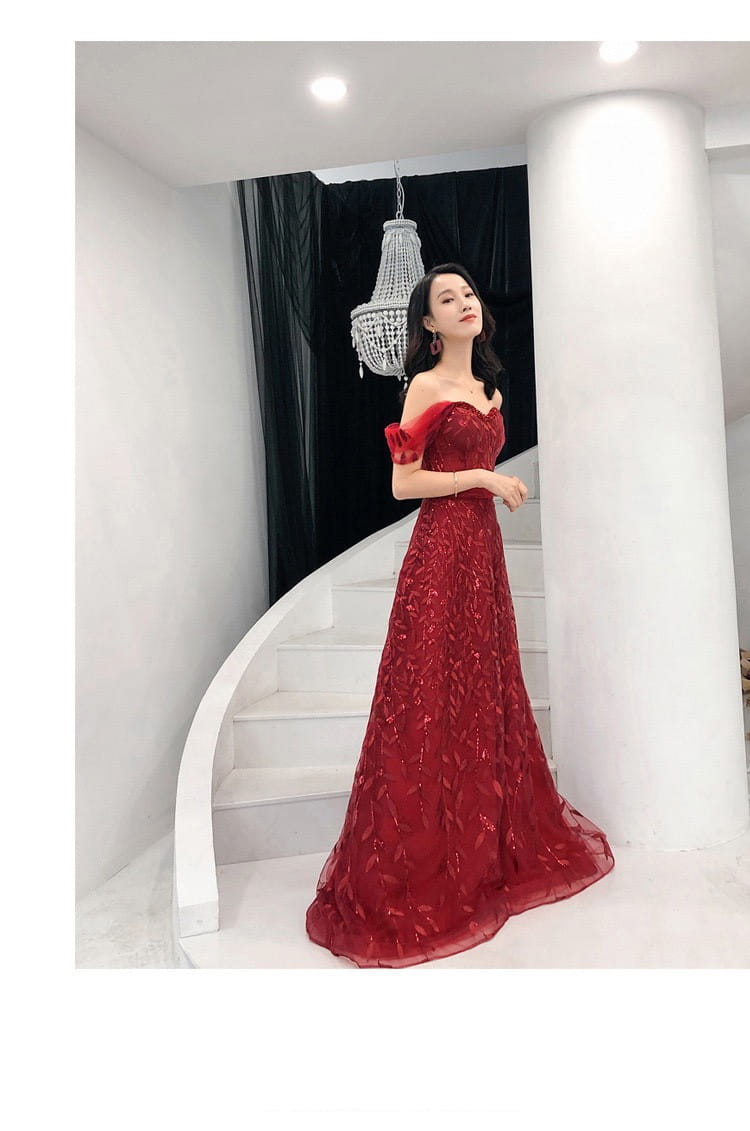 A flowing deep red off-the-shoulder evening dress featuring intricate lace detailing and a lace slim slimming fitted silhouette suitable for bridal occasions.