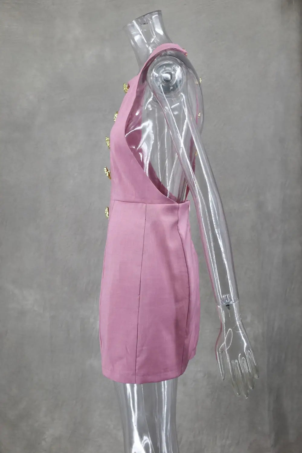 Back view of sleeveless pink mini dress with fitted silhouette and gold rose buttons down the back