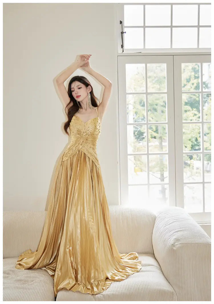a shimmering gold satin heavy industry birthday dress featuring intricate beaded detailing at the bodice and a flowing floor-length skirt