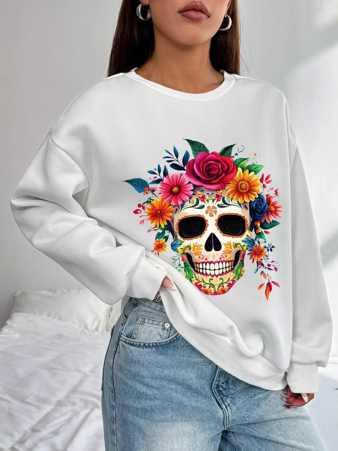 white oversized crew neck sweatshirt featuring a vibrant colorful floral skull design with roses and blossoms in pink yellow orange and blue ideal for daily wear and as a basic long sleeve garment