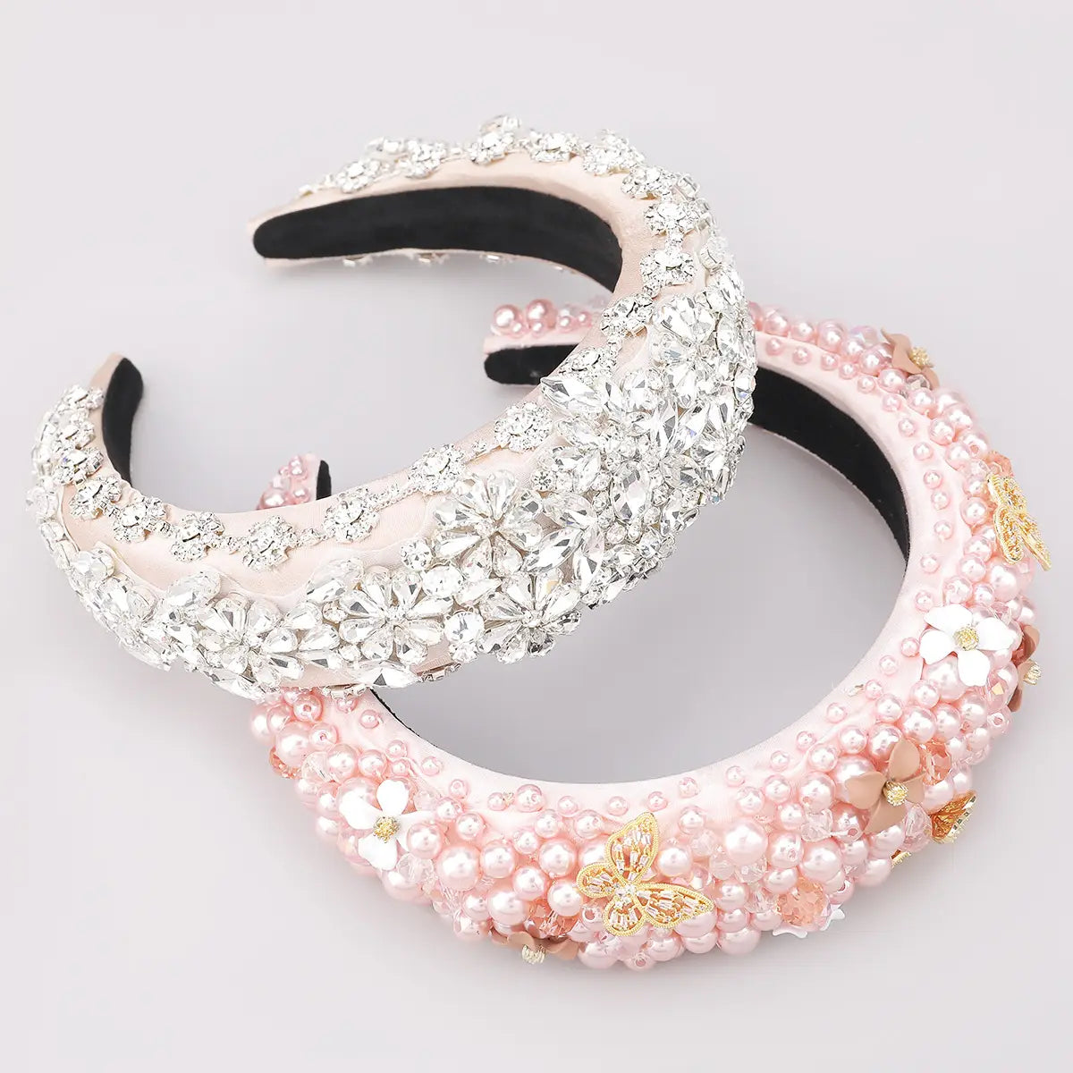 A fashionable personality hair pink floral headband with a soft satin base embellished with sparkling crystals, pearls, and golden butterfly accents, highlighting elegant hair accessories fabric.