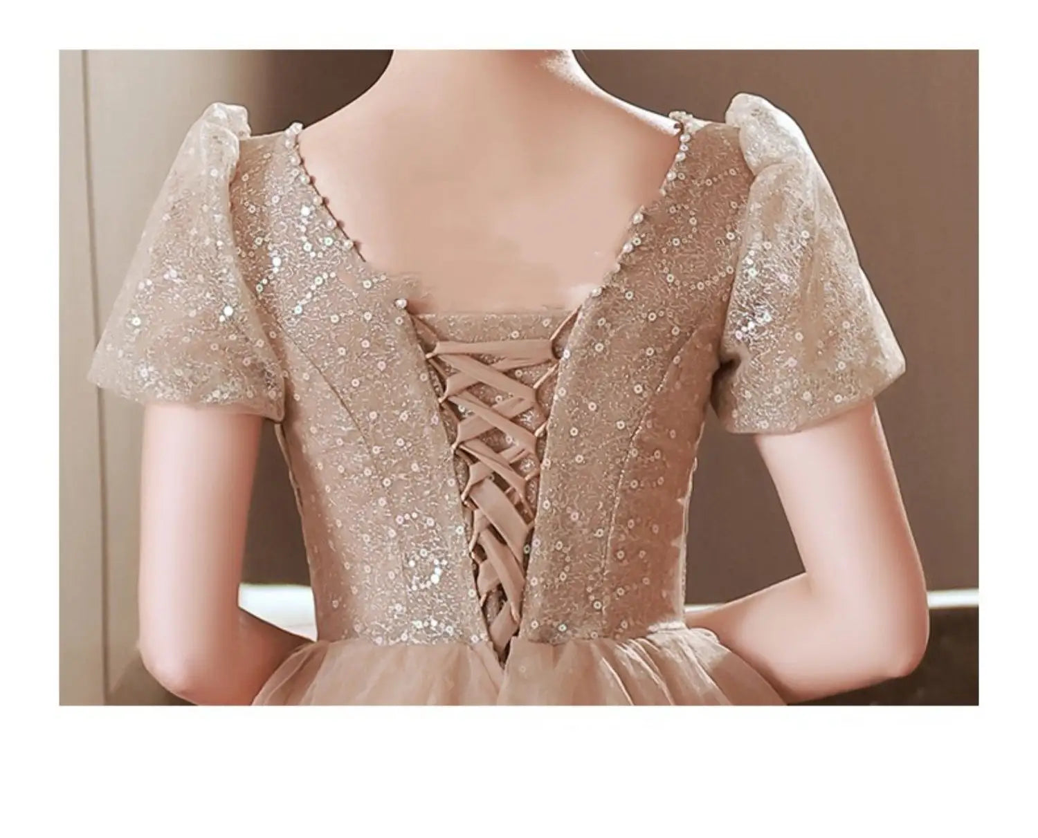 blush beaded tulle luxury evening dress in shimmering champagne lace with short puffed sleeves and delicate back corset lacing showcasing the back side of this luxury evening dress