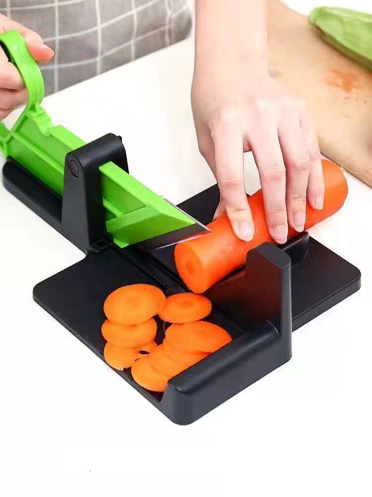 Multifunctional green and black vegetable cutting meat slicer with a sharp blade designed for evenly cutting carrots into thin rounds for vegetable cutting kitchen use.