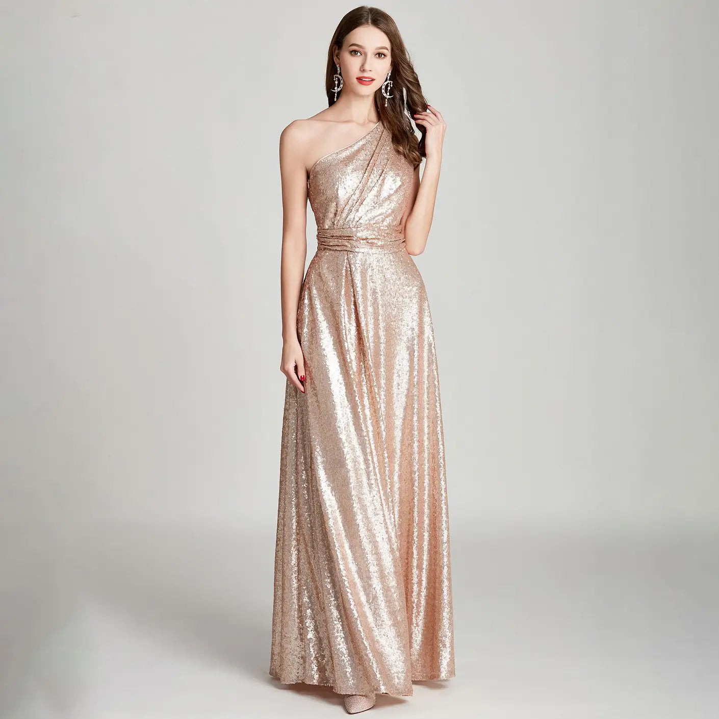 a shimmering rose gold sequined one shoulder floor-length evening dress with a cinched waist designed as a large bridesmaid dress for banquets