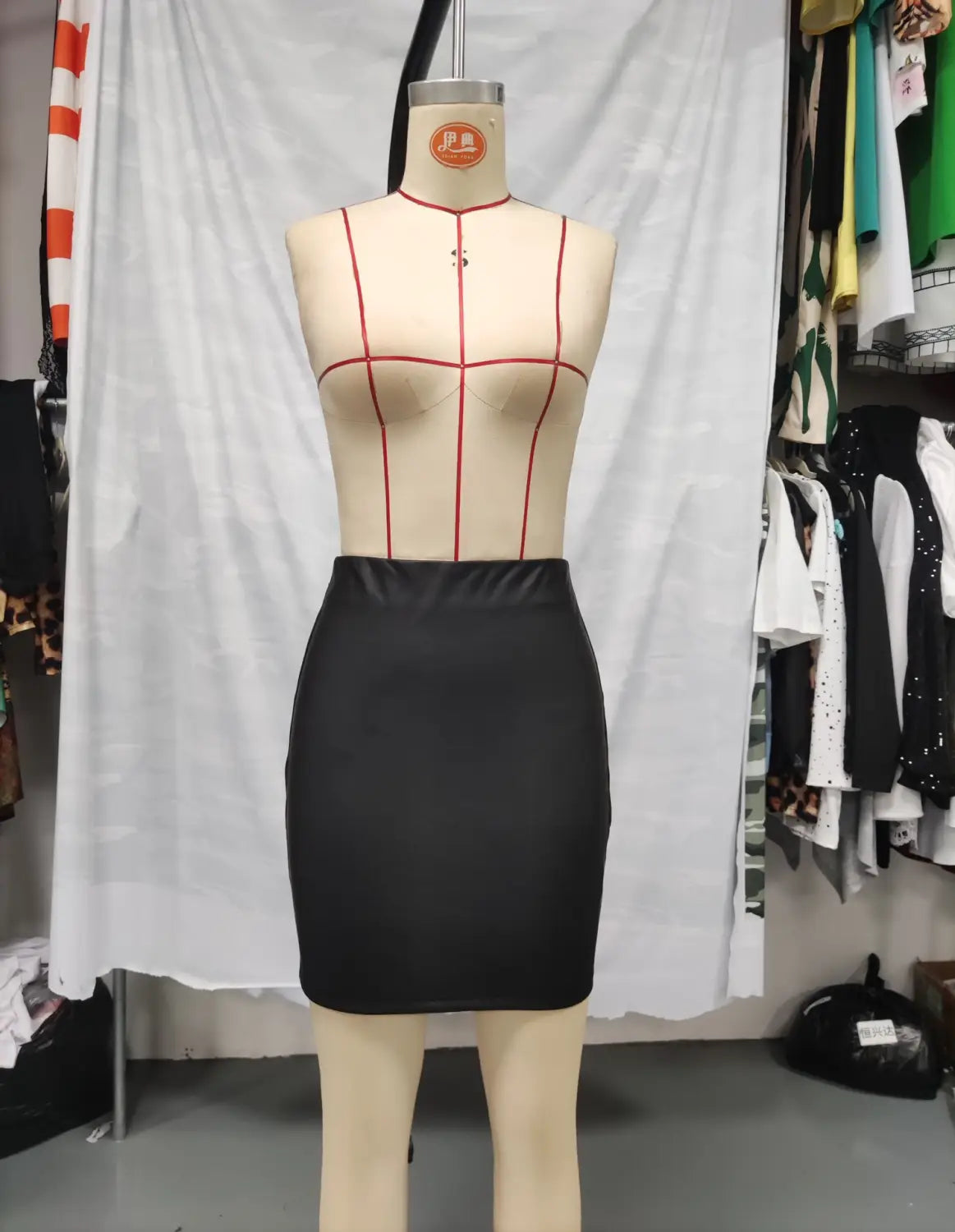 black high waist ruched tight pu leather mini skirt displayed on a mannequin