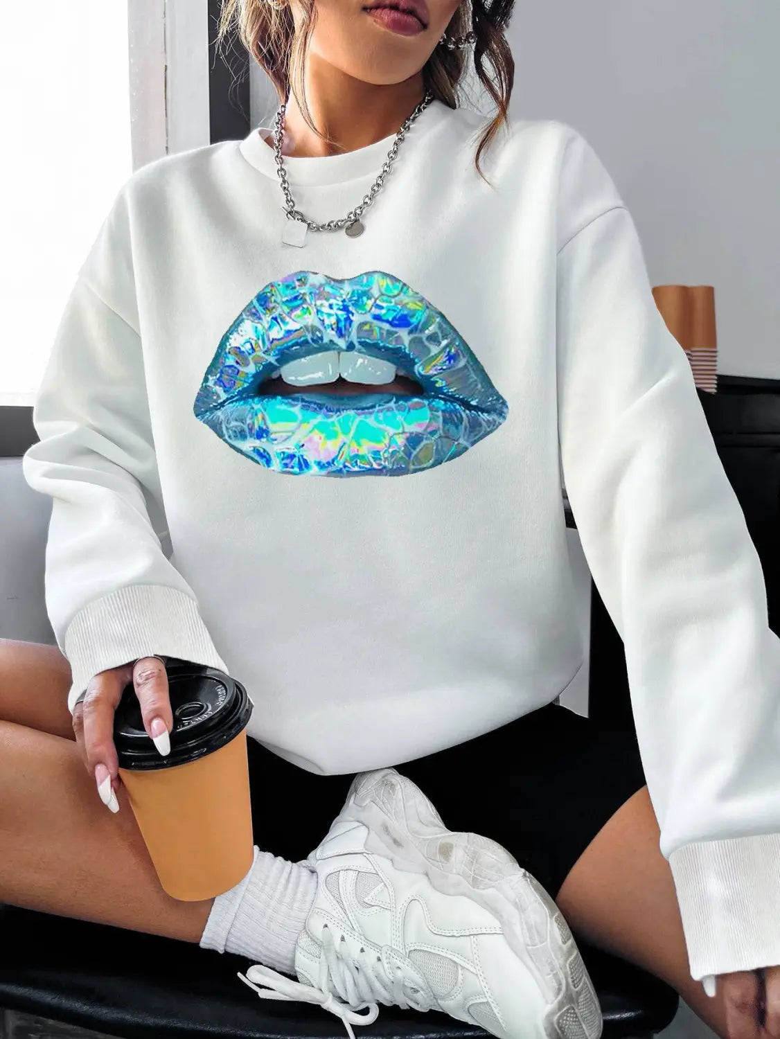 White crew neck long sleeve sweatshirt featuring a large iridescent blue holographic lip graphic for women