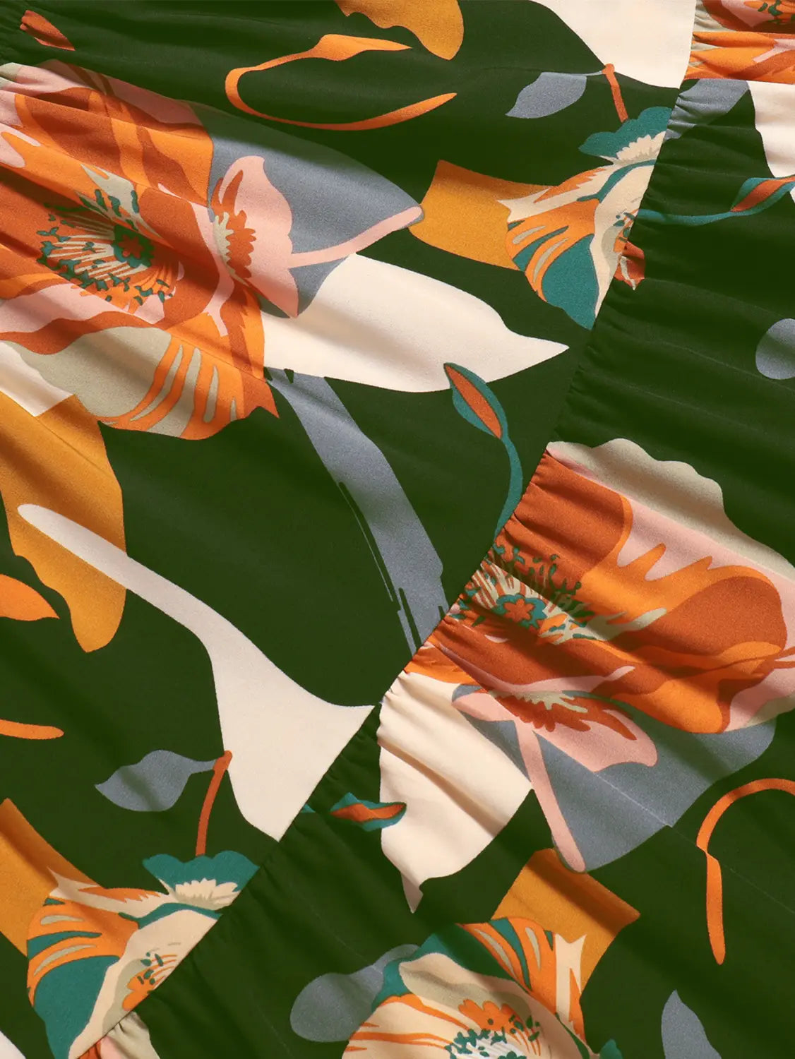 Cream tiered pleated floral print skirt featuring bold orange white and teal blossoms on a deep green floral print elastic waist for comfortable fit.