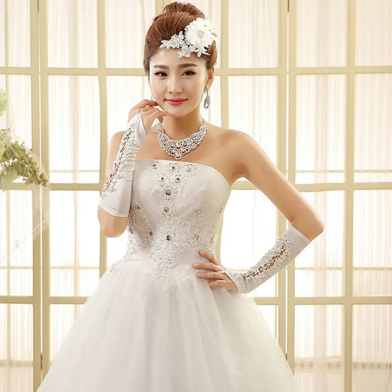 White strapless korean style tube wedding dress with intricate lace and beading on the bodice paired with matching long gloves