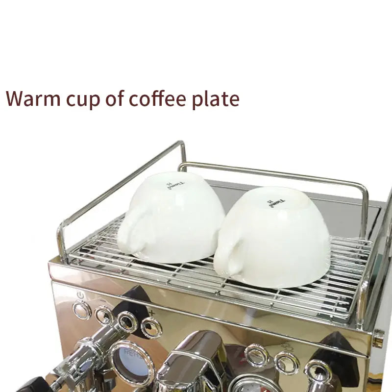 two white ceramic espresso cups rest upside down on the stainless steel rack of a stainless steel semi-automatic espresso machine