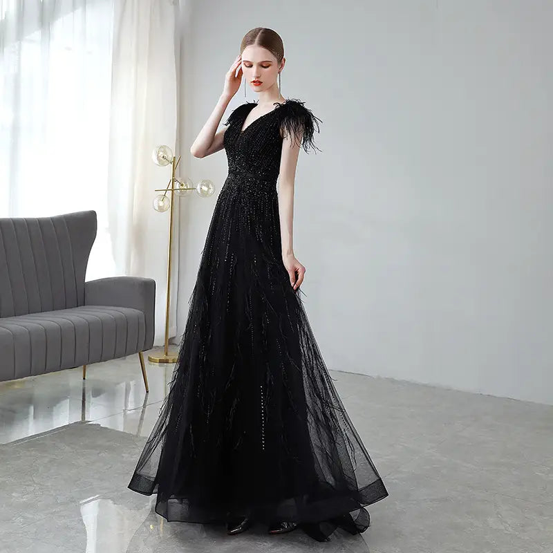 Elegant black double shoulder evening dress featuring feather embellishments and a sequined bodice ideal for formal occasions.