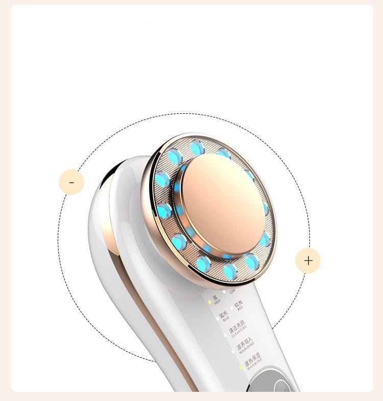 White and rose gold 7 in 1 led facial machine with circular head featuring blue led lights around a central peach-colored treatment pad for skin care and facial massage.