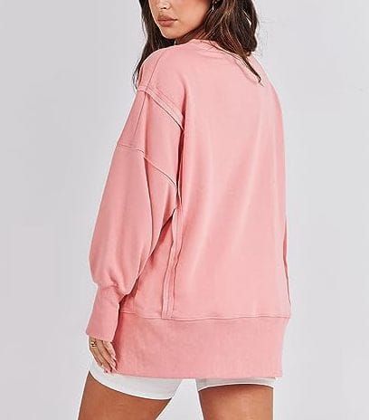 A soft pink solid oversized sweatshirt with side zippers featuring a relaxed fit and subtle seam detailing in a sweatshirt crew neck design.