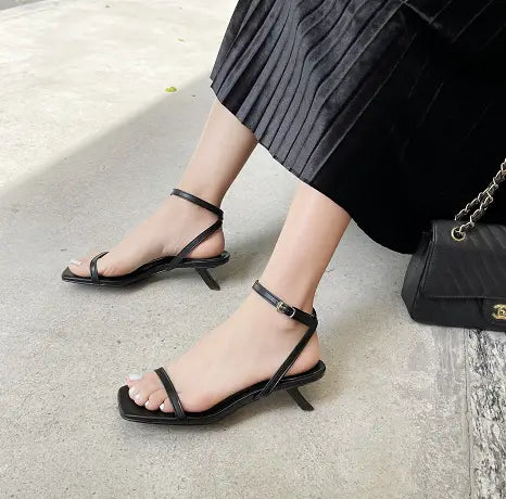 black leather strappy heeled sandals with minimalist design and thin ankle strap featuring a square toe stiletto style
