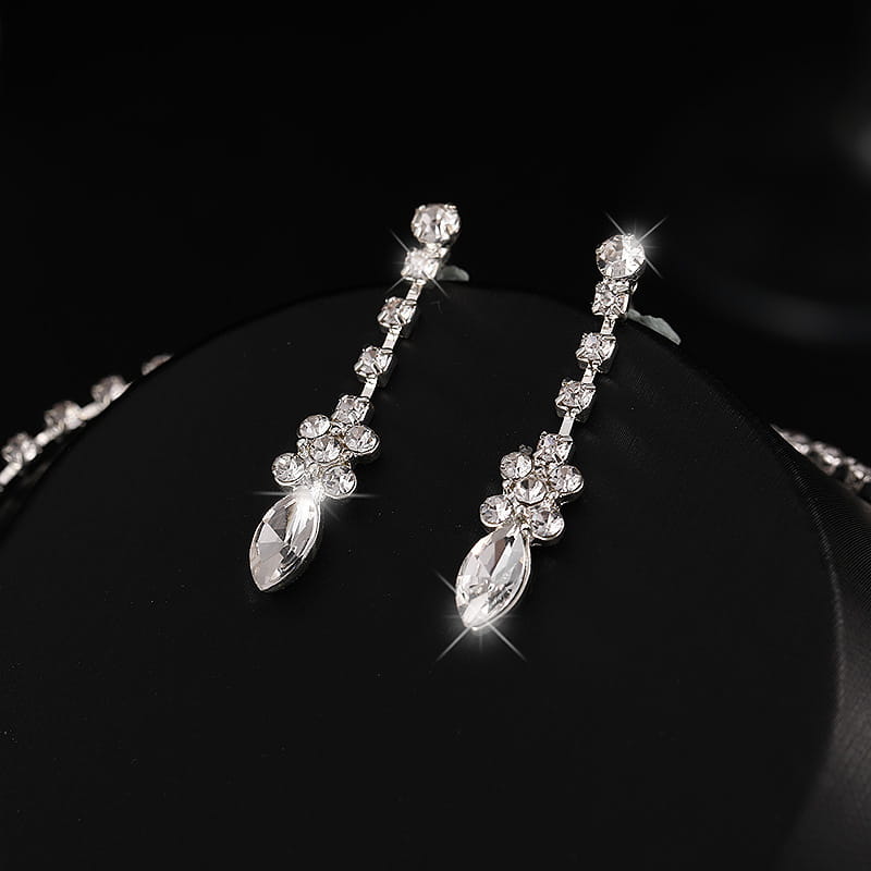 Crystal drop earrings set in silver-toned metal featuring a cascade of clear rhinestones and a prominent marquise-cut stone, complementing a luxury zircon necklace for luxury women’s fashion.