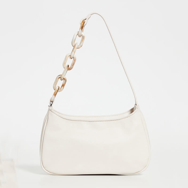 A sleek white trendy small crocodile bag made of faux leather featuring a distinctive tortoiseshell-patterned acrylic chain strap.