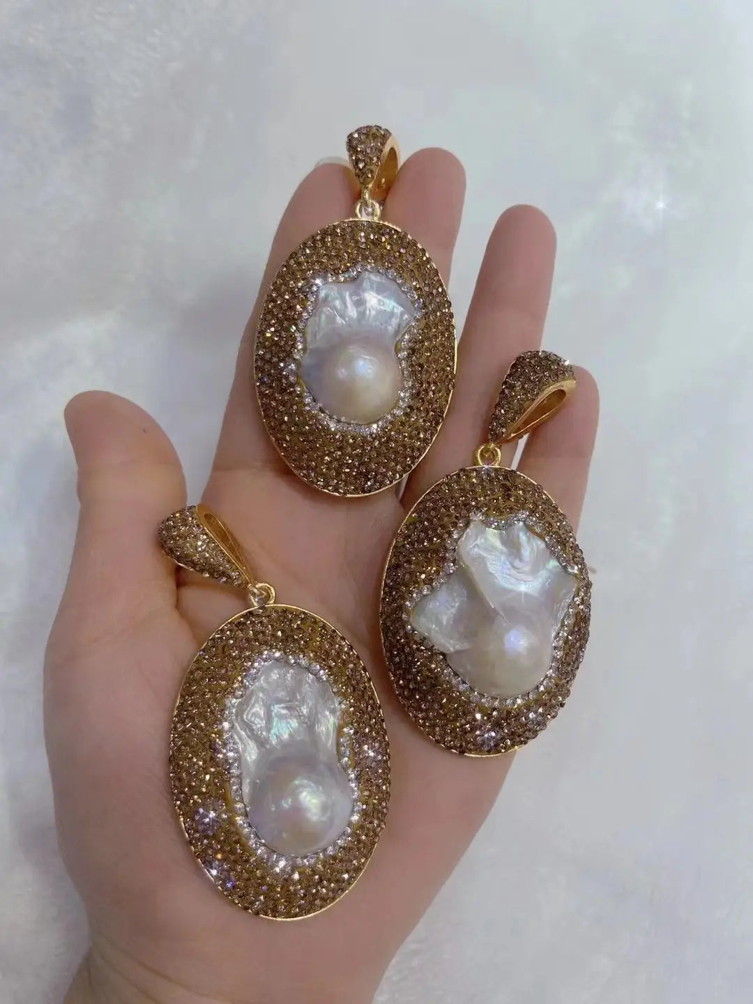 gold-toned baroque pearl necklace ring suit featuring oval iridescent pearls encased in a pave setting of sparkling brownish crystals designed as a ring suit bride ornament