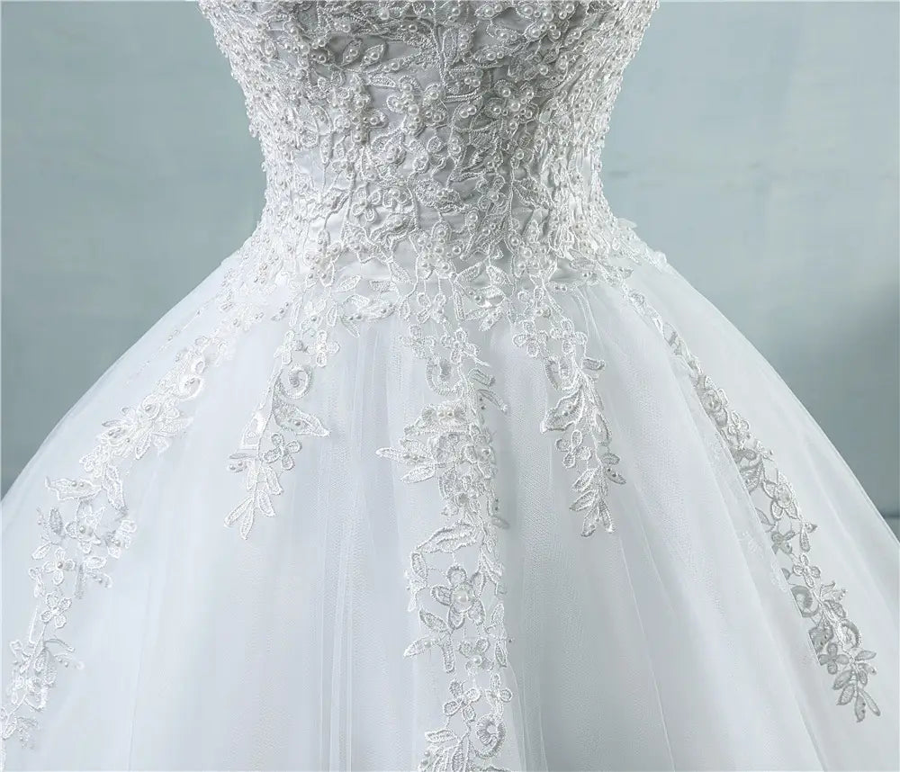 A white lace v neck high waist wedding dress featuring intricate lace detailing and a flowing tulle skirt for a waist wedding dress look.