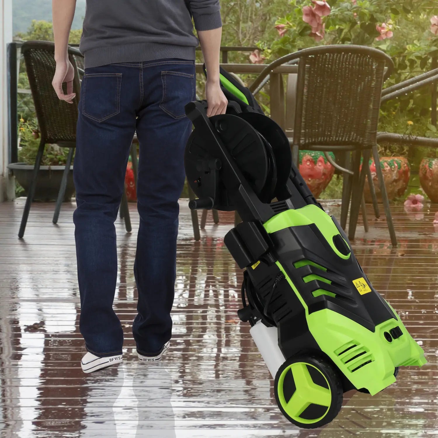 A lime green and black high pressure cleaner with a built-in coiled hose reel, wheels for mobility, and a compact design suitable for outdoor cleaning tasks.