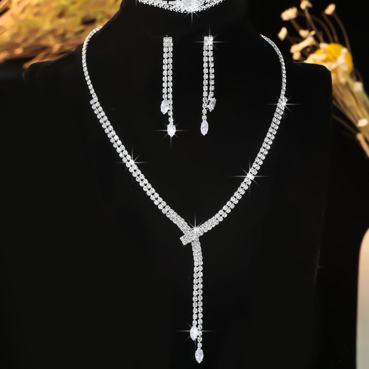 Sparkling silver rhinestone fashion simple necklace with v-shaped design and dangling crystal drop paired with matching simple necklace earring bracelet set.