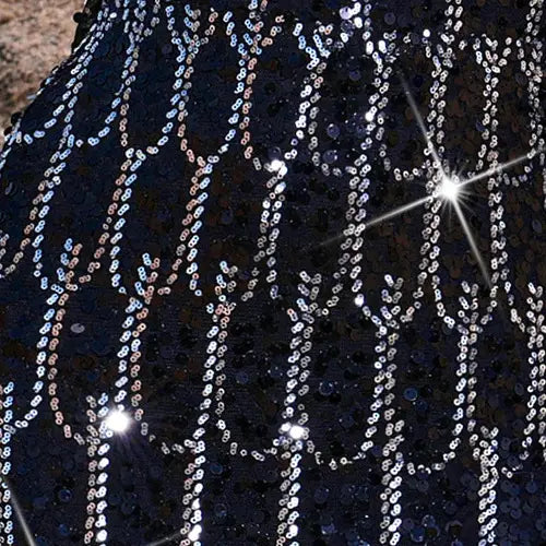 Black sequined long sleeve round neck evening dress featuring a shimmering fabric adorned with vertical rows of silver and iridescent beads forming a sparkling tree-like pattern.